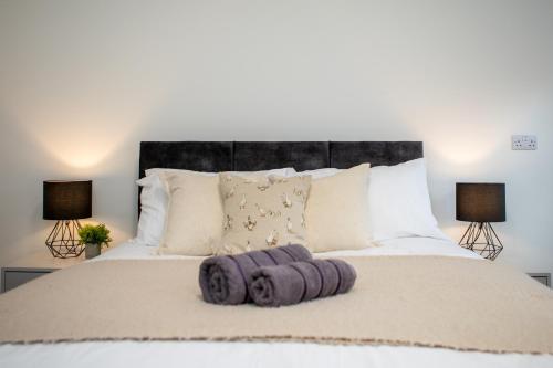 a bedroom with a bed with purple towels on it at St James Court Hotel in Derby