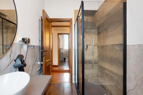 a bathroom with a shower and a sink and a mirror at Appartamento 3 in Viareggio