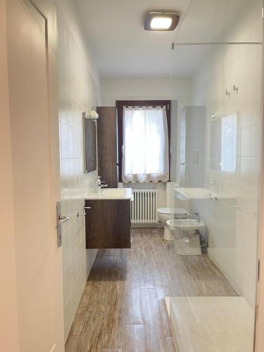 a bathroom with two sinks and a toilet and a window at Da Gas e Nana casa vacanze con salottino esterno vicino Venezia e Treviso in Peseggia