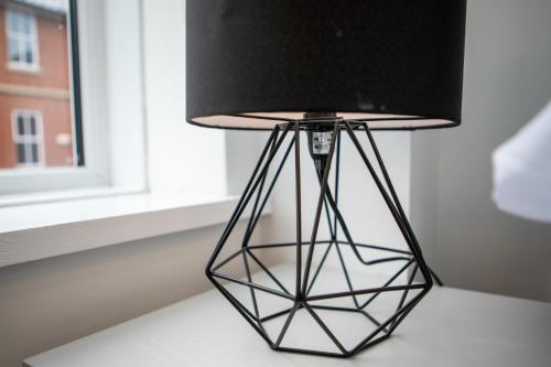 a black lamp sitting on a table next to a window at St James Court Hotel in Derby