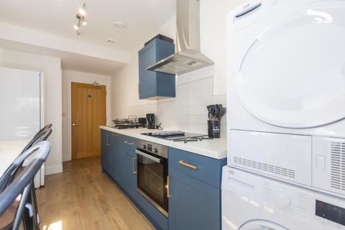 a kitchen with blue cabinets and a stove top oven at St James Court Hotel in Derby