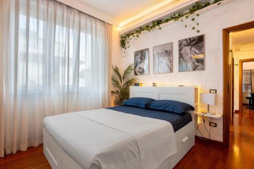 a bedroom with a large white bed with blue pillows at Appartamento 3 in Viareggio