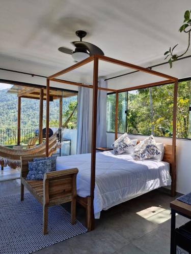 a bedroom with a canopy bed and a hammock at Segunda Casa-CASA DE TEMPORADA in Paraty