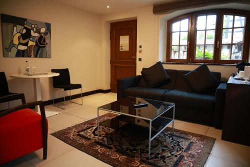 a living room with a couch and a table at Hotel - Restaurant Le Cerf & Spa in Marlenheim