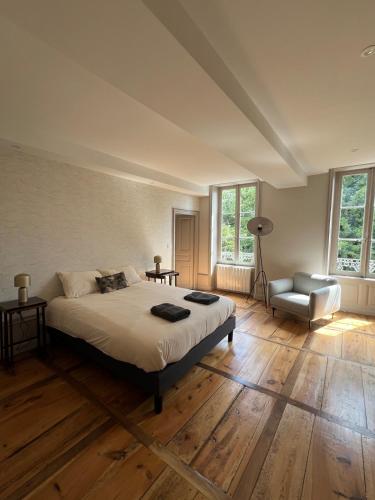 un dormitorio con una cama y una silla en Château de Sampigny - 10 min from Clermont-Ferrand, en Gerzat