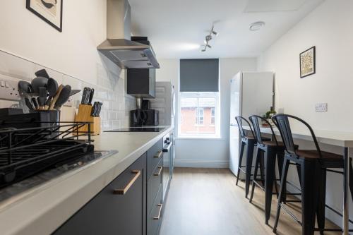 a kitchen with a counter and some chairs in it at St James Court Hotel in Derby