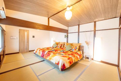 a bedroom with a bed and a large window at Lax奈良 奈良観光に便利な和モダン古民家 最大12名 グループや家族旅行に最適 in Nara