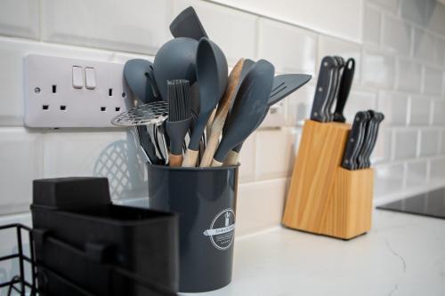 a black cup filled with utensils on a kitchen counter at St James Court Hotel in Derby