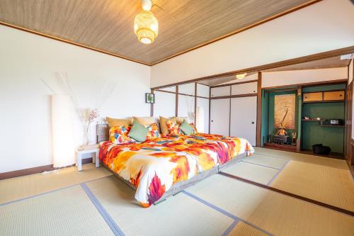 a bedroom with a large bed with a colorful comforter at Lax奈良 奈良観光に便利な和モダン古民家 最大12名 グループや家族旅行に最適 in Nara