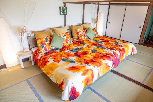 a bedroom with a bed with a colorful comforter at Lax奈良 奈良観光に便利な和モダン古民家 最大12名 グループや家族旅行に最適 in Nara