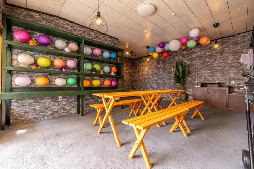 two picnic tables in a room with colorful eggs on the wall at Lax奈良 奈良観光に便利な和モダン古民家 最大12名 グループや家族旅行に最適 in Nara