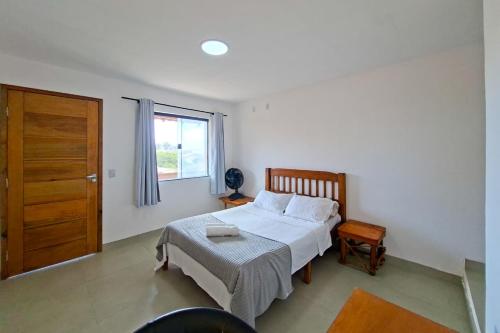 a bedroom with a bed and a window and a door at Suíte casal in Arraial do Cabo