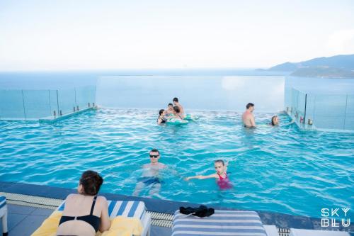 a group of people swimming in a swimming pool at MAISON SEAFRONT RESIDENCE Nha Trang in Nha Trang