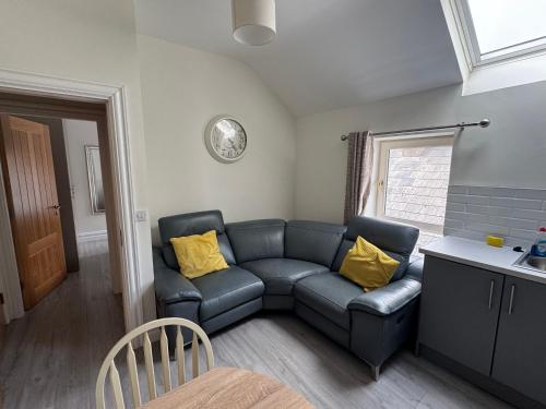 a living room with a blue couch and yellow pillows at Unit 3 Modern Self Contained Apartment in Cobh