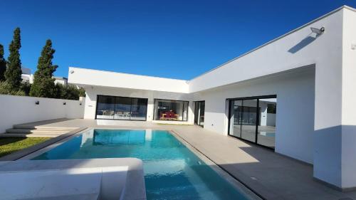 a swimming pool in the backyard of a house at Villa Elyssa Hammamet in Hammamet