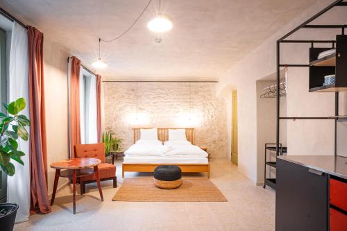 a small bedroom with a bed and a table at Apartmány Oblouk - stylové ubytování v historickém jádru města in Žatec