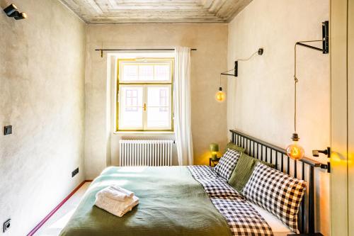 a bedroom with a bed and a window at Apartmány Oblouk - stylové ubytování v historickém jádru města in Žatec