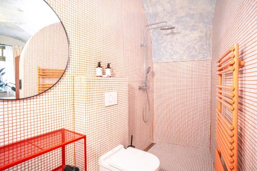 a bathroom with a shower with a toilet and a mirror at Apartmány Oblouk - stylové ubytování v historickém jádru města in Žatec