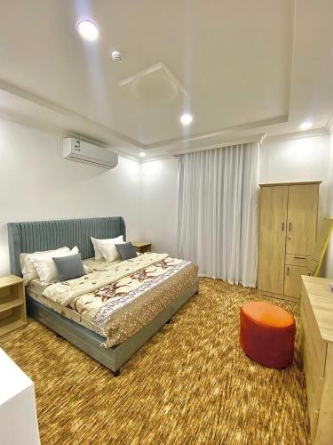 una camera da letto con un letto e uno sgabello rosso di شقق الشعله المخدومه a Riyad