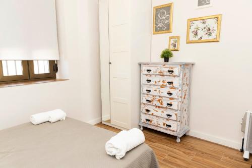a bedroom with a bed and a dresser with shoes at Casa rural DOS ENCINAS in Andújar