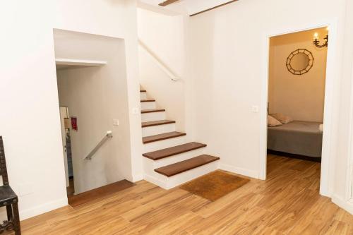 a staircase in a white room with a bed at Casa rural DOS ENCINAS in Andújar