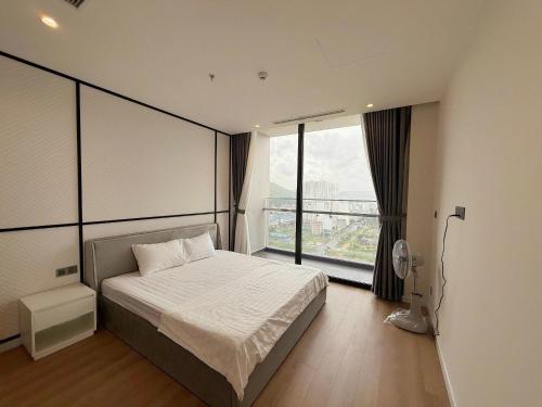 a bedroom with a bed and a large window at ICON40 Ha Long Luxury Apart in Ha Long