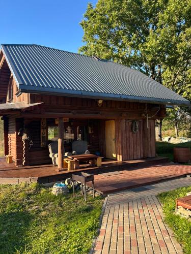 a log cabin with a porch and a table at Pūnas Sauna in Lenči