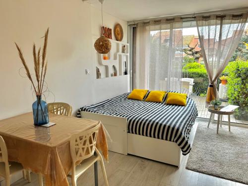 a bedroom with a bed with yellow pillows and a table at Appartement * Palavas-les-flots * Piscine in Palavas-les-Flots