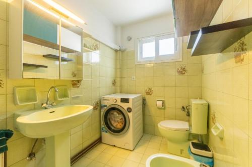 y baño con lavabo y lavadora. en Serenity Paxos, en Gáios