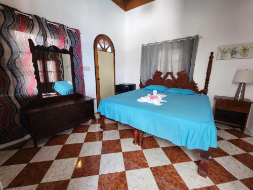 a bedroom with a blue bed and a mirror at Kaisers Sunset Hotel - Adults Only, Negril in Negril