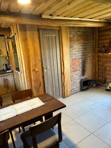 a dining room with a table and a brick wall at Pūnas Sauna in Lenči