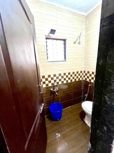 a bathroom with a toilet and a blue bucket at Kiran Villa stay Home in Pune