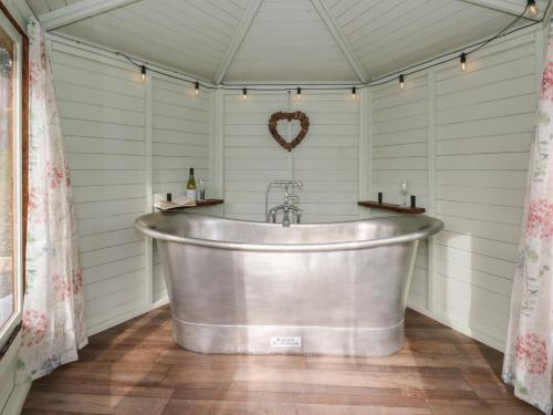 a bath tub in a room with white walls at Y Cwlwm - The Celtic Knot in Lampeter