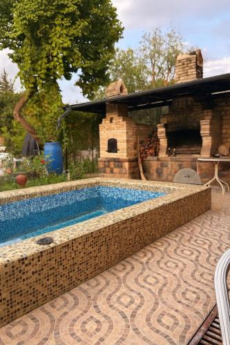 una piscina frente a una casa con chimenea en The Hideaway House, en Dzoraghpʼyur