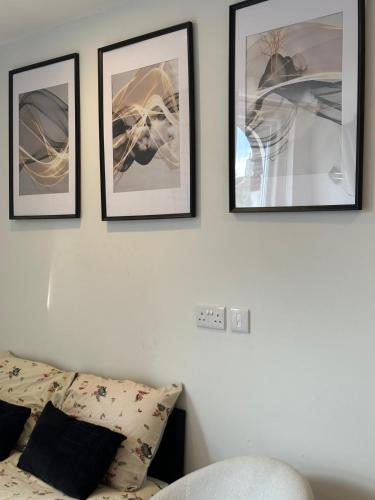four pictures hanging on a wall above a bed at Brigstock 6 in Thornton Heath