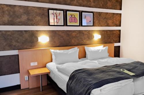 a bedroom with a large bed with two pillows at Garner Hotel Cottbus Süd by IHG in Cottbus