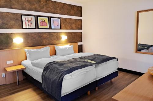 a bedroom with a large bed in a room at Garner Hotel Cottbus Süd by IHG in Cottbus