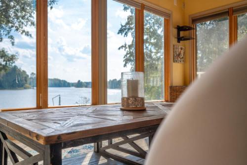 a table with a candle on it in a room with windows at Lake Days Getaway in Hillsborough
