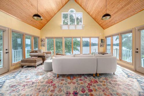 a large living room with white couches and windows at Lake Days Getaway in Hillsborough