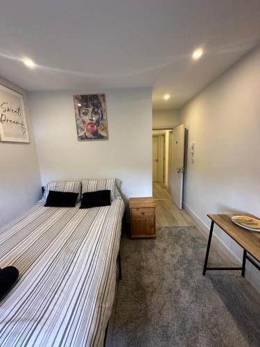 a bedroom with two beds and a wooden table at Brigstock3 in Thornton Heath