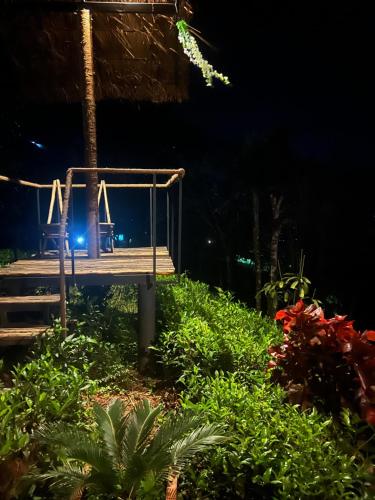 a wooden deck with chairs on the beach at night at Mount Lux Villa in Devāla