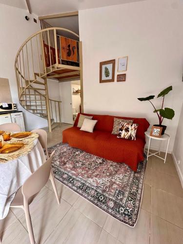 a living room with a red couch and a staircase at Le Voile de la Mariée in Salazie