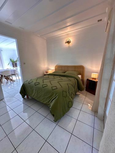 a bedroom with a bed and a tiled floor at Le Voile de la Mariée in Salazie