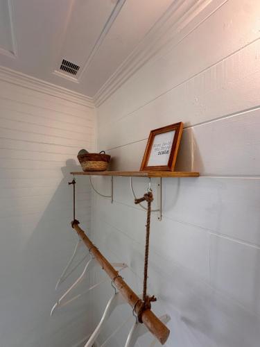a shelf on the wall with a book and a basket at Le Voile de la Mariée in Salazie