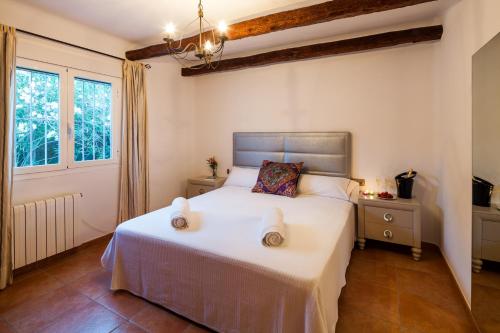 a bedroom with a bed and a window at El Charco in Cala Llonga