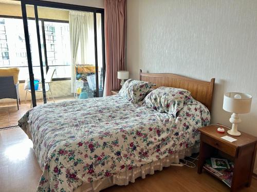 a bedroom with a bed with a floral bedspread and a table at Acogedor depto con vista al mar in Viña del Mar