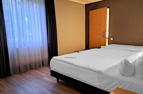 a bedroom with a large bed and a window at Garner Hotel Cottbus Süd by IHG in Cottbus