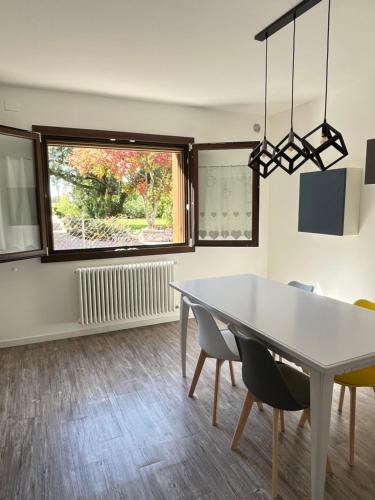 a dining room with a table and chairs and a window at Da Gas e Nana in Peseggia
