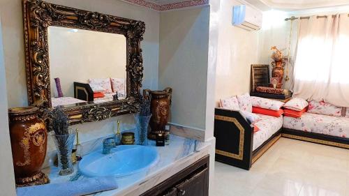 a bathroom with a sink and a mirror and a bed at Appartement abdessalam fetouaki in Moulay Yacoub