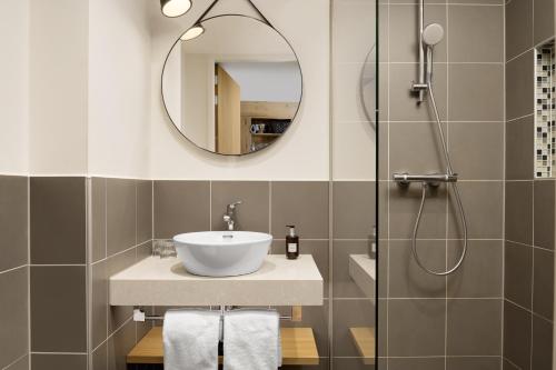 a bathroom with a sink and a shower at Residence Inn by Marriott Amsterdam Houthavens in Amsterdam
